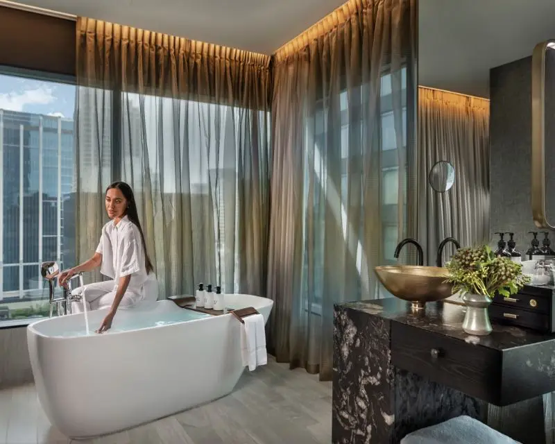 http://A%20person%20in%20the%20hotel%20room%20bathroom%20with%20a%20frestanding%20bathtub%20about%20to%20take%20a%20bath