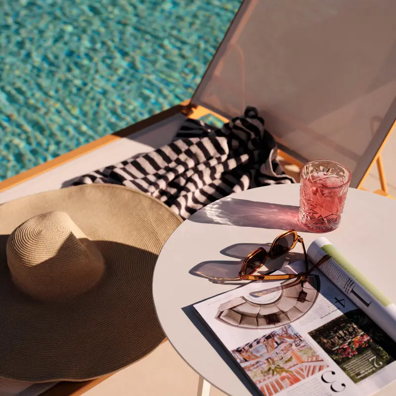 Pool lounger with sunglasses on a table
