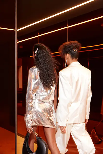 http://Two%20stylish%20guests%20walk%20into%20the%20mirrored%20lift.
