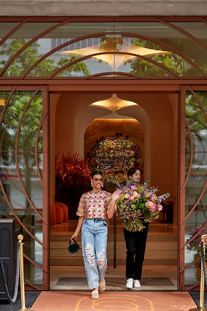 http://Two%20guests%20walk%20through%20the%20entrance%20to%20the%20hotel.
