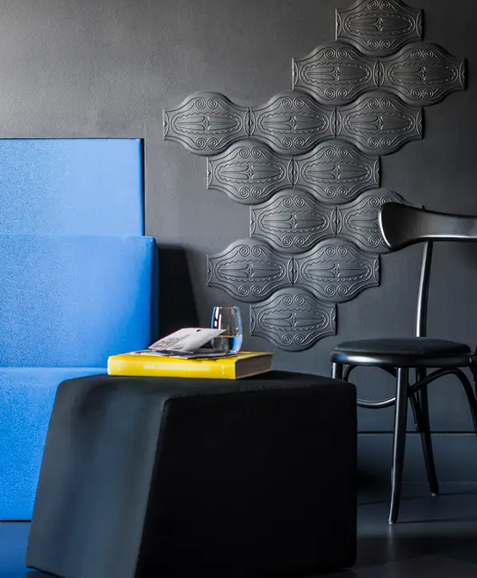 http://Black%20side%20table%20and%20chair%20with%20abstract%20artwork%20behind%20on%20the%20wall