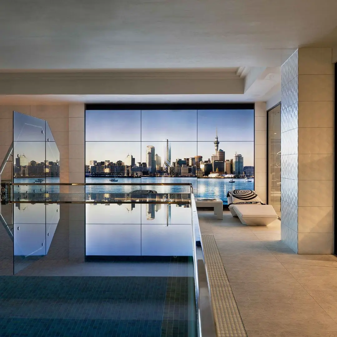 A luxurious interior view featuring a sleek swimming pool with a stunning skyline reflecting in the water at dusk.